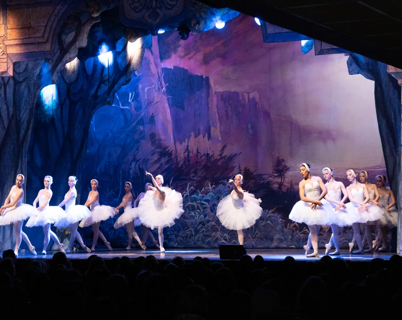Dancers on a lit stage during a ballet performance
