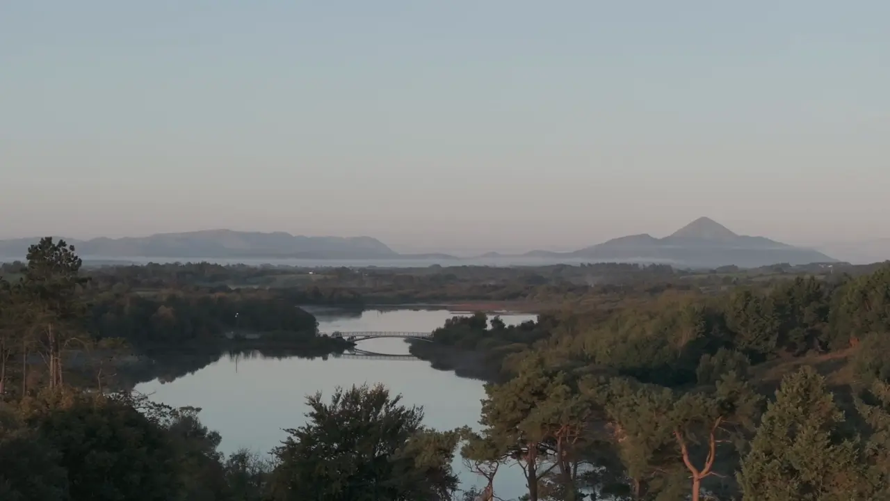 A rowing crew on a still lake at dawn